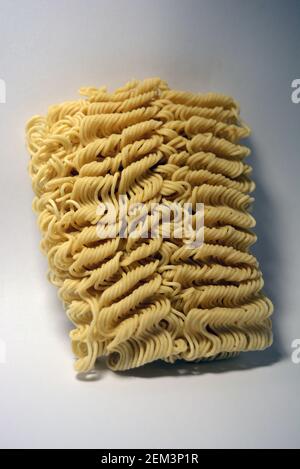 Instant vermicelli, Brikett aus dünnen, langen vermicelli auf weißem Hintergrund gesetzt. Stockfoto