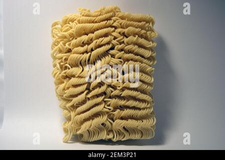 Instant vermicelli, Brikett aus dünnen, langen vermicelli auf weißem Hintergrund gesetzt. Stockfoto