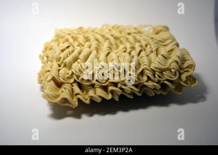 Instant vermicelli, Brikett aus dünnen, langen vermicelli auf weißem Hintergrund gesetzt. Stockfoto