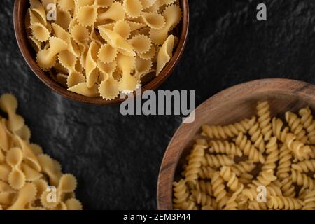 Holzschüsseln voller roher Farfalle tonde und girandole Pasta Stockfoto