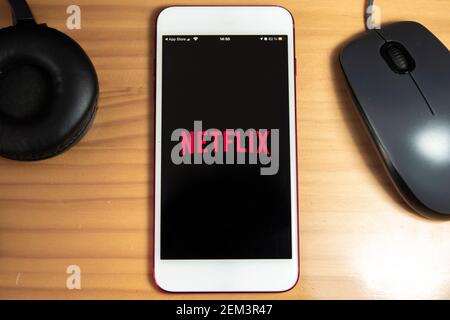 Spanien, 02, 24, 2021: Apple Smartphone mit Netflix-Anwendung Startbildschirm in einer Tabelle Stockfoto