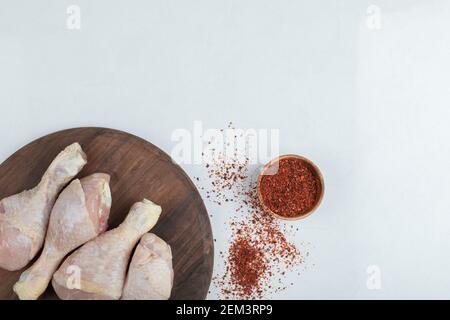 Roh frische Hähnchenbeine auf Holzbrett mit rot heiß Chili Stockfoto