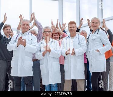 Ärzte und eine Gruppe reifer Menschen applaudieren Stockfoto