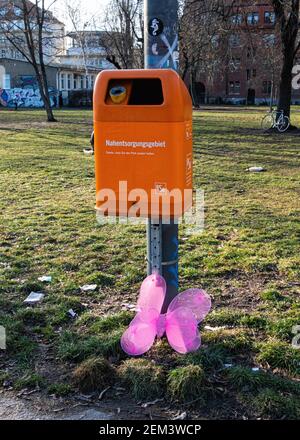 Verlassene oder gedumpte rosa Schmetterling neben einem orangen Müll Kann in Mitte, Berlin, Deutschland Stockfoto