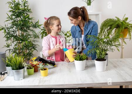 Teenager-Mädchen mit einer Gartenschaufel Werkzeug, um eintopfende Erde in einem Blumentopf setzen, Gartenkonzept Stockfoto