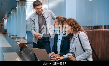 Junge Geschäftsleute mit einem Laptop auf dem U-Bahnsteig. Stockfoto