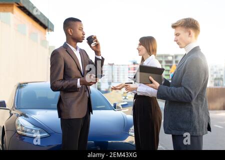 Multiethnical Business Group, zwei Männer und Frauen mit einer Kaffeepause, mit Tablet und Smartphones und diskutieren über Arbeit und Projekt, stehend Stockfoto