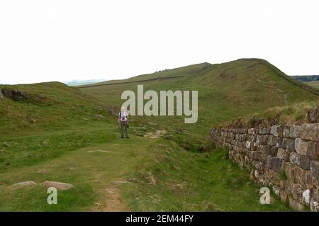 Hadrians Wall Pennine Way England Hill Fort Walker Girl Blonde Stock Hill Walkway Stein gebaut von den Römern römische Invasoren Schottischen Schotten Stockfoto