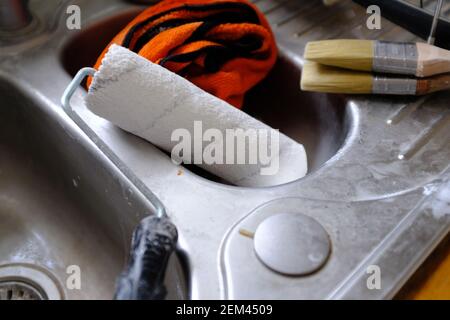 Färben Sie die Pinsel und die Walze, die im Spülbecken trocknet. Stockfoto