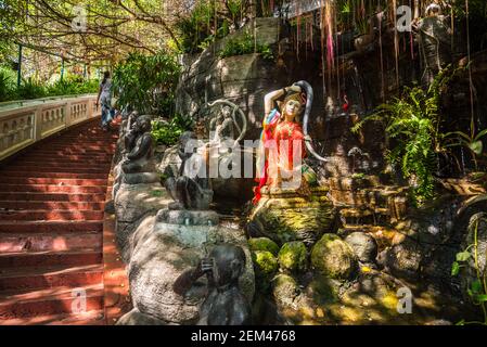 Treppe zum Tempel Wat Saket (Goldener Berg) in Bangkok, Thailand. Schöne Bäume, Pflanzen und Skulpturen an der Seite. Stockfoto