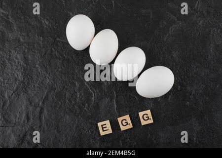 Weiße Hühnereier auf schwarzem Hintergrund Stockfoto