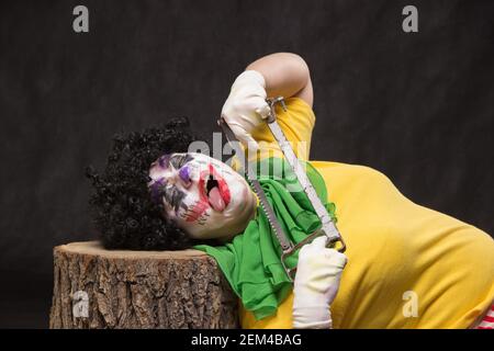 Unheimlich bösen Clown mit einem hässlichen Lächeln und sah auf einem schwarzen backgroun Stockfoto
