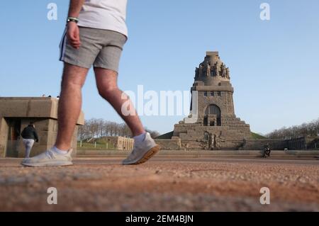 Leipzig, Deutschland. Februar 2021, 24th. Ein Mann in kurzen Hosen geht vor dem Monument der Völkerschlacht entlang. Am Mittwoch wurden in der Messestadt, dem wärmsten Februartag seit 1863, 19,6 Grad Celsius gemessen. Quelle: Sebastian Willnow/dpa-Zentralbild/dpa/Alamy Live News Stockfoto