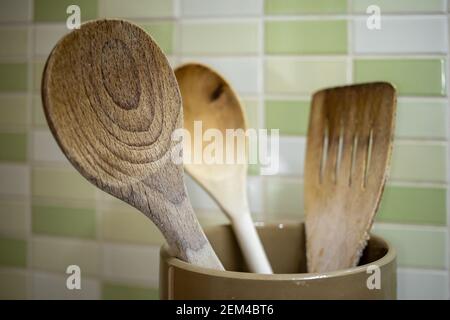 Küchenutensilien in einem Keramiktopf - Holzlöffel und Spatel zum Kochen von Speisen Stockfoto