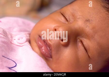 Extreme Nahaufnahme Gesicht eines niedlichen schlafen neugeborenes Baby. Nahaufnahme Porträt eines süßen einen Monat alten Kleinkind Jungen gefangen in schläfriger Stimmung. Vorderansicht. Stockfoto