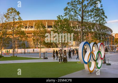 tokio, japan - januar 13 2020: Olympic Rings Denkmal auf dem japan Sport olympic Square of Japan Olympic Museum mit dem Olympiastadion in Backgroun Stockfoto