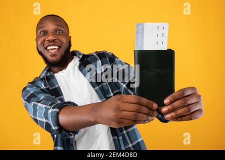Aufgeregt Black Man Zeigt Travel Tickets Posieren Auf Gelbem Hintergrund Stockfoto
