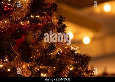 Weihnachtsbaum mit einer Girlande und verschiedenen Spielsachen geschmückt Stockfoto