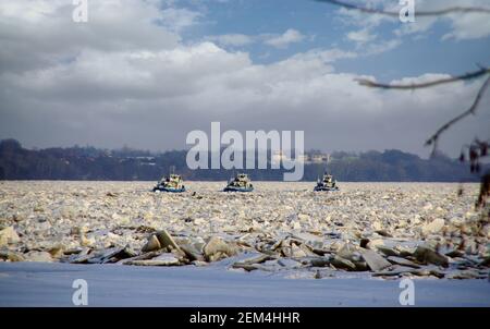 Eisbrecher in der Wintersaison in Betrieb. Zerbrechende Eisschollen auf dem Fluss. Stockfoto