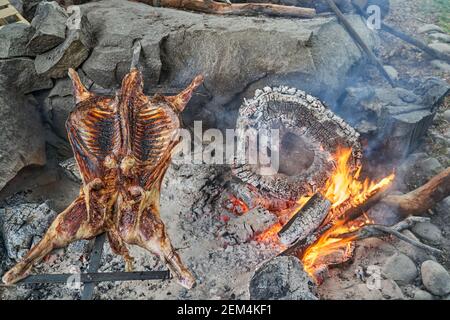 Rustikales Lamm Grill bbq über offenem Feuer in Patagonien, Argentinien, Südamerika. Asado ist ein Gaucho Traditon mit Kochen auf offener Flamme Stockfoto