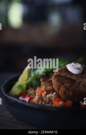 Fishcakes Lachs mit Hafer und Salat auf hölzernen Tisch Stockfoto