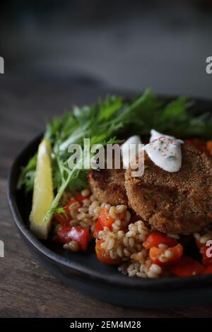 Fishcakes Lachs mit Hafer und Salat auf hölzernen Tisch Stockfoto