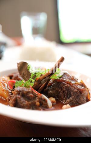 Rindfleisch Massaman Curry mit Reis und Salat auf Holz- Hintergrund, Thai Food Stockfoto