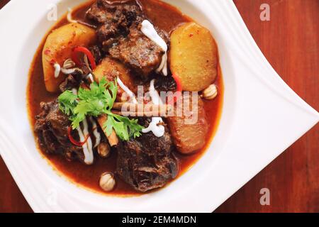 Rindfleisch Massaman Curry mit Reis und Salat auf Holz- Hintergrund, Thai Food Stockfoto