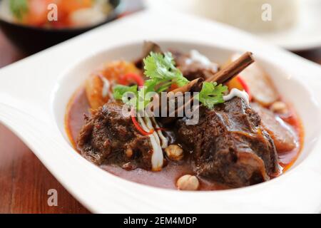 Rindfleisch Massaman Curry mit Reis und Salat auf Holz- Hintergrund, Thai Food Stockfoto