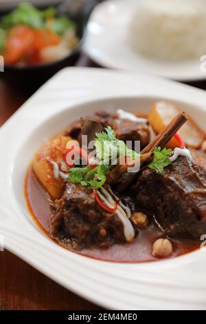 Rindfleisch Massaman Curry mit Reis und Salat auf Holz- Hintergrund, Thai Food Stockfoto