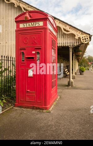 Eine ungewöhnliche Kombination aus Briefmarkenautomat, Briefkasten und öffentlichem Telefonkiosk an einem historischen Bahnhof in Somerset UK Stockfoto