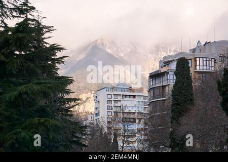 Morgen Stadtbild in bergigen Gegend - Wohngebäude auf der Hintergrund von nebligen Bergen Stockfoto