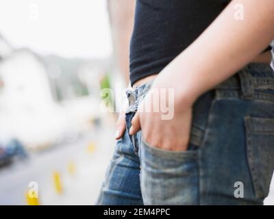 Mitte Schnittansicht einer Frau stehend mit den Händen in den Taschen Stockfoto