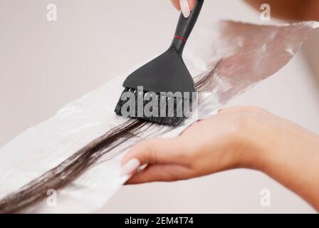 Nahaufnahme der Hände eines Friseurs, die Haare färben Stockfoto