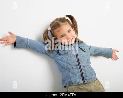 Porträt eines Mädchens stehend gegen eine Wand und lächelnd Stockfoto