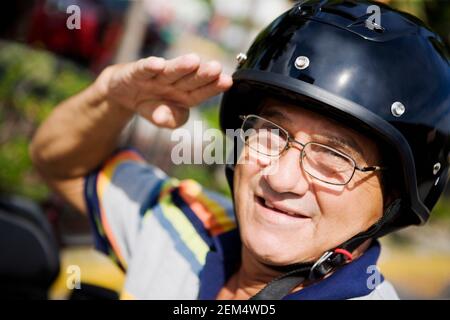 Porträt eines reifen Mannes trägt einen Motorradhelm und Begrüßung Stockfoto