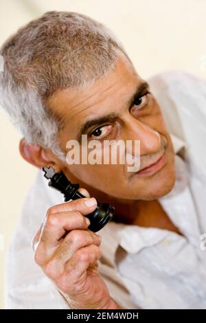 Porträt eines älteren Mannes, der ein Schachstück hält Stockfoto