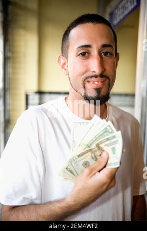 Porträt eines jungen Mannes mit Wad von zwanzig und Ein Dollar Banknoten und lächelnd Stockfoto