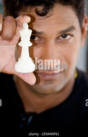 Porträt eines jungen Mannes, der ein Schachstück zeigt Stockfoto