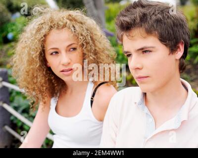 Nahaufnahme eines jungen Mannes, der mit einem Teenager-Mädchen denkt Neben ihr sitzen Stockfoto