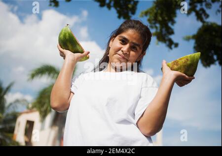 Portrait eines Mädchens, das Wassermelonenscheiben hält und lächelt Stockfoto