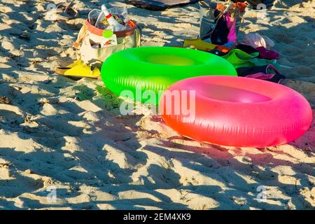 Zwei aufblasbare Ringe und Taschen am Strand Stockfoto