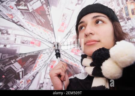 Low-Angle-Ansicht eines Teenagers, das einen Regenschirm hält Stockfoto