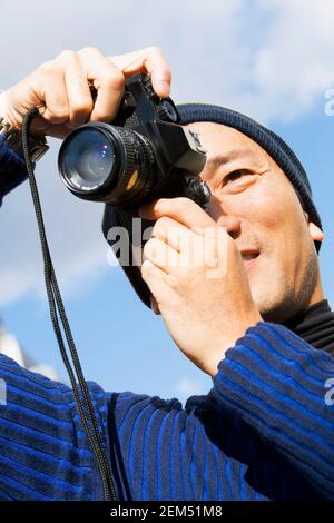Low-Angle-Ansicht eines mittleren Erwachsenen Mann nimmt ein Bild Stockfoto