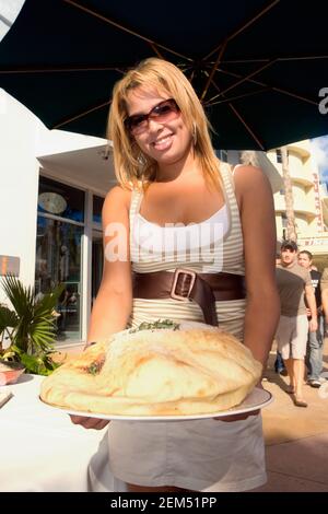 Porträt einer Kellnerin, die einen Teller Naan Brot hält Stockfoto