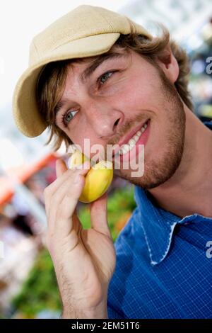 Nahaufnahme eines jungen Mannes, der eine Banane auf sich hält Ohr als Telefonhörer Stockfoto