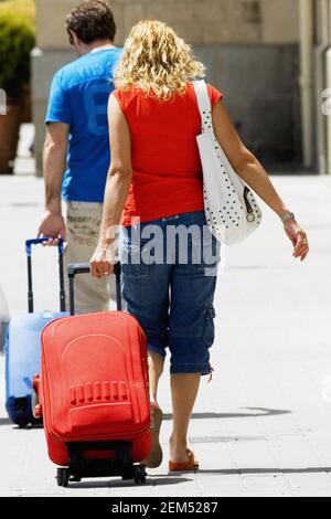 Rückansicht eines Mannes und einer Frau, die mit Gepäck laufen, Toledo, Spanien Stockfoto