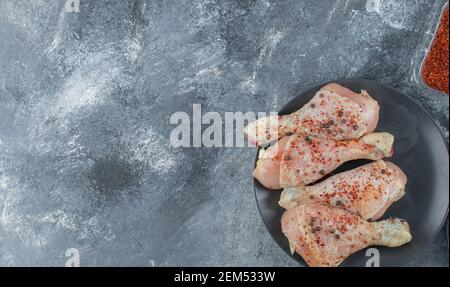 Rote scharfe Chilischote und marinierte rohe Hähnchenschenkel Stockfoto