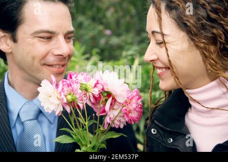 Nahaufnahme eines Mannes mit mittlerem Erwachsenen und einer jungen Frau Hält einen Blumenstrauß Stockfoto