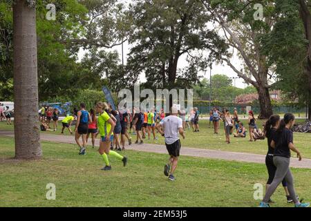 Menschen laufen und gehen in einem Stadtpark. Stockfoto